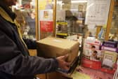 Customers weigh packages at the post office.