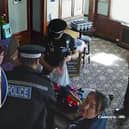 CCTV footage shows police storming a couple's Essex pub and seizing their golliwog dolls, saying the toys were a suspected hate crime (Photos: SWNS)