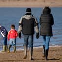 Family playing at the seaside in winter, Instow, Devon, UK. (Photo by: Education Images/Universal Images Group via Getty Images)