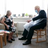 Prime Minister Boris Johnson talks to resident Kathleen during a visit to Westport Care Home in east London on September 7, 2021. - Breaking an election pledge not to raise taxes, British Prime Minister Boris Johnson today announced hefty new funding to fix a social care crisis and a pandemic surge in hospital waiting lists. (Photo by Paul EDWARDS / POOL / AFP) (Photo by PAUL EDWARDS/POOL/AFP via Getty Images)