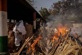 A priest avoids funeral pyres in India, which has been badly hit by a surge in coronavirus cases. (Photo by Anindito Mukherjee/Getty Images)