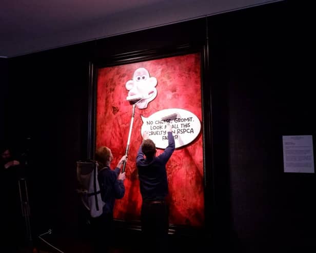 Protesters pasting over the royal portrait (Photo: Animal Rising/Supplied)