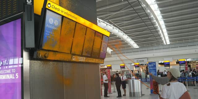 Just Stop Oil cover Heathrow Airport Terminal 5's departure boards in orange paint.