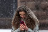 Woman on a smartphone in a snowstorm. Photo: ANATOLII STEPANOV/AFP via Getty Images