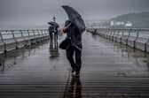 People battle against the wind and rain.