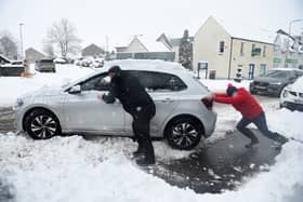 Stock image of car being pushed out of snow.