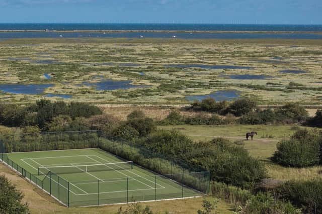 The all-weather tennis court is situated away from the house, close to the Norfolk Coastal Path