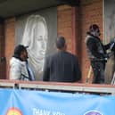 Guillem Balague and Braima Fati watch David Nash put the finishing touches to the new murals at Biggleswade United. Picture by Tia Thorne