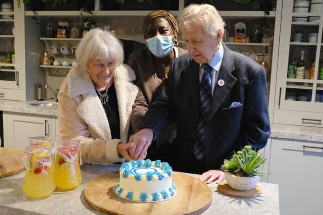 Iris and Ernest cut the celebratory cake