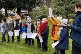 School children sing to hospice volunteers and staff