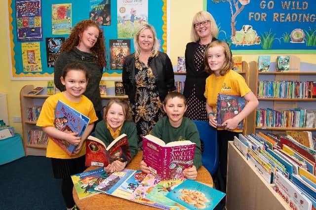 (Left to right) Eloise Murphy of the PTA, Alison Humber of Davidsons Homes and Head of School Margaret Newman, with Meppershall Church of England Academy pupils in the school’s library.
