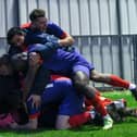 Charlie Black is buried underneath a pile of his Biggleswade United team-mates after he scored what proved to be the crucial winning goal in the vital 1-0 success over relegation rivals ON Chenecks last weekend. Picture courtesy of Cosmin Iftode/Phoro Studio