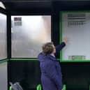 A bus passenger peering at the timetable above her head. Credit: Alan Bailey