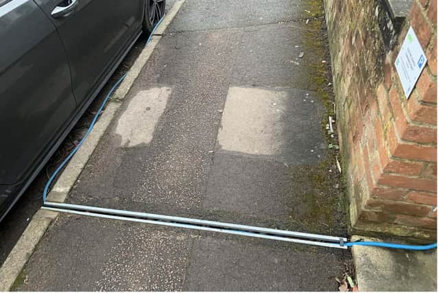 A purpose-built cable channel that is laid in the footway to allow the safe trailing of a charging cable from property to vehicle. (The image is illustrative and shows a prototype version of the product installed in Oxford).