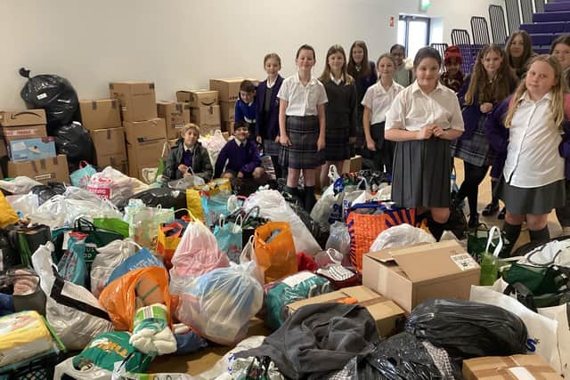 Pix Brook pupils proudly stand next to items donated by the school community.