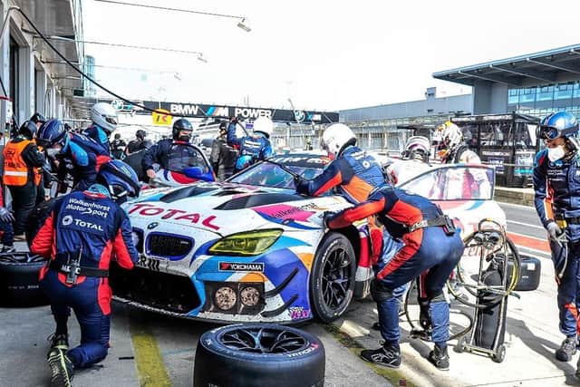 The team work on the car in the pits