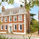 The symmetrical faade has five bays of sashed windows, with the front door situated in the middle bay on the ground floor.