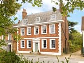 The symmetrical faade has five bays of sashed windows, with the front door situated in the middle bay on the ground floor.