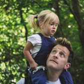 Dad carrying his daughter on his shoulders through an RSPB nature reserve.