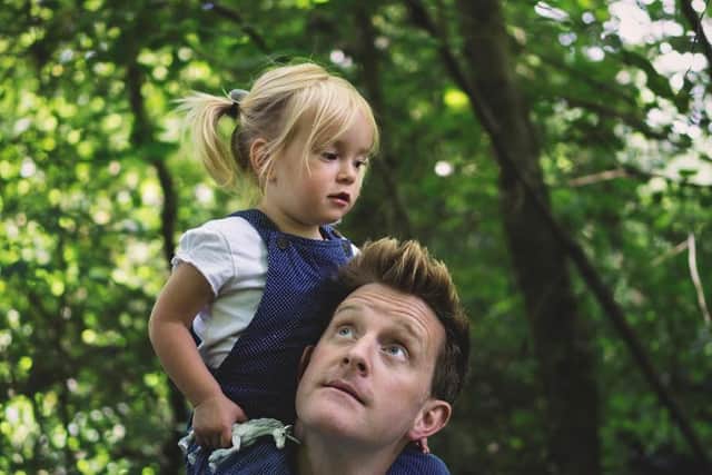 Dad carrying his daughter on his shoulders through an RSPB nature reserve.