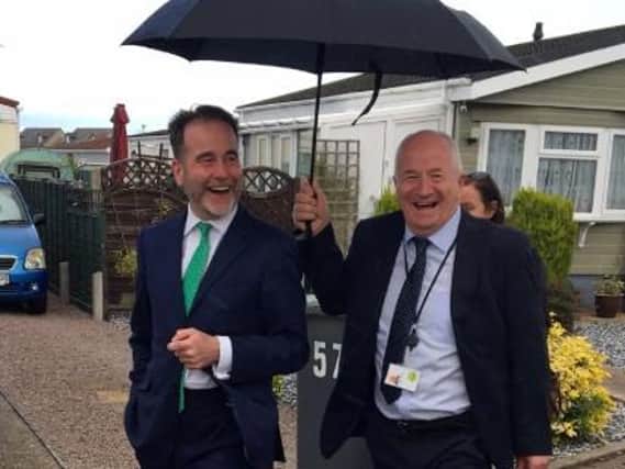 Cllr Eugene Ghent helped to shelter Housing Minister RT Hon Christopher Pincher MP from the rain as they took a tour of the park to see the improved homes.