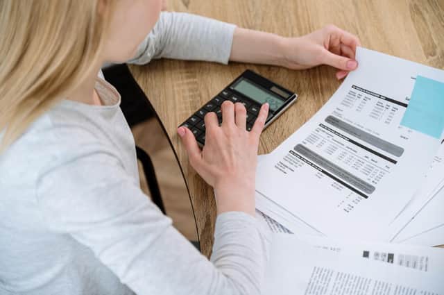 Busy woman working at home office calculating and paying utility bills for house rent.
