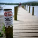 A sign on the shore warns bathers and swimmers about toxic algae in Lake Windermere. (Photo by Christopher Furlong/Getty Images)