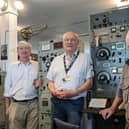 Left to right: Volunteers Nick Gilder, Alf Fisher, and Dave Thompson at a 1940s World War Two air traffic control desk. Image: Dave Thompson.