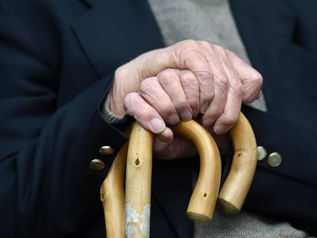 File photo of an elderly man holding a walking stick.