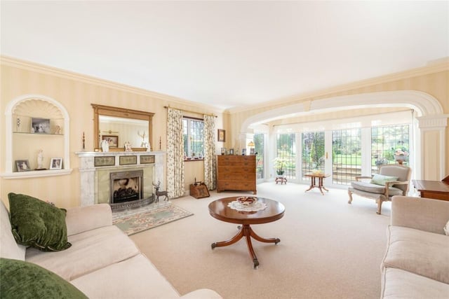 Under a decorative elliptical arch, the drawing room has box bay windows overlooking the garden, with glazed double doors to the terrace. There is a marble fireplace with a raised hearth, housing a Living Flame gas fire
