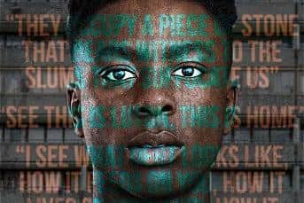 Actor Olatunji Ayofe stood in front of council flats with play quotes over his face.