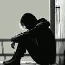File photo of a teenage boy sitting alone in the dark