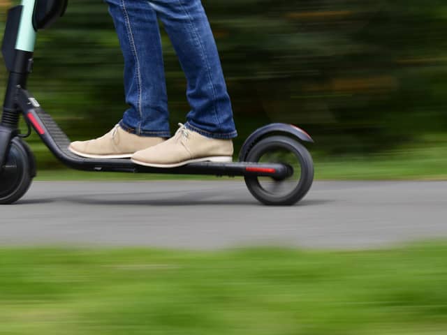 A man rides an e-scooter. (Photo by TOBIAS SCHWARZ/AFP via Getty Images)