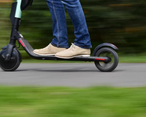 A man rides an e-scooter. (Photo by TOBIAS SCHWARZ/AFP via Getty Images)