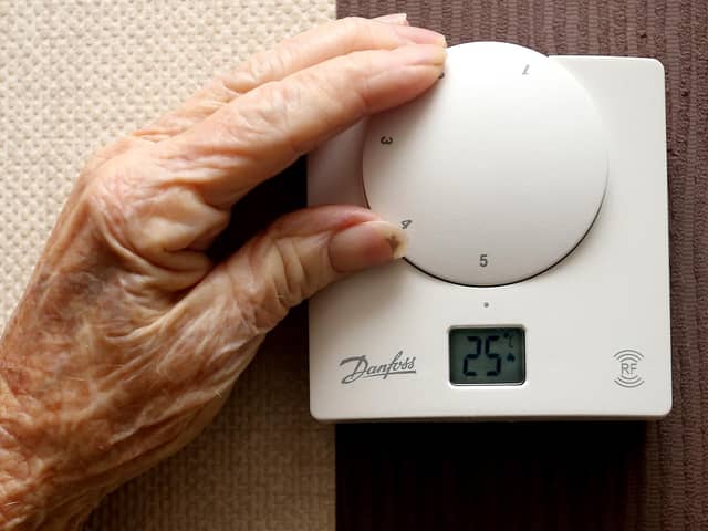 File photo of an elderly lady adjusting her thermostat