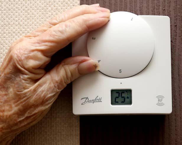 File photo of an elderly lady adjusting her thermostat