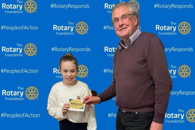 Rotary President Keith Austin presenting the Amazon Voucher for £100 to Madison Ford from Caldecote CE Academy PTFA team.