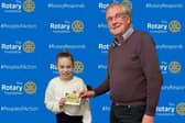 Rotary President Keith Austin presenting the Amazon Voucher for £100 to Madison Ford from Caldecote CE Academy PTFA team.
