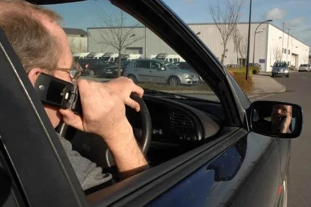 Man using his phone whilst driving. Picture: Anna Gowthorpe via PA