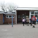 Children arrive at a school.
