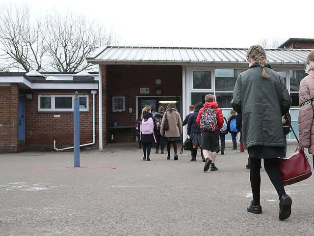 Children arrive at a school.