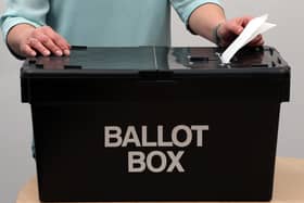 File photo of a person putting a vote into a ballot box