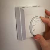 Undated file photo of a person using a central heating thermostat.