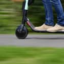 File photo of a person on an e-scooter (Photo by TOBIAS SCHWARZ/AFP via Getty Images)