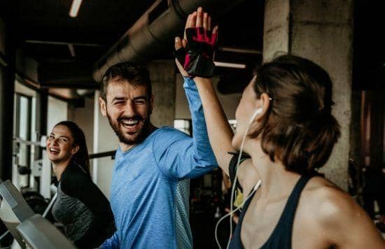 Stock image of three people on treadmills in a gym.