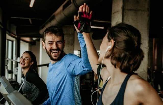 Stock image of three people on treadmills in a gym.