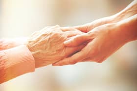 File photo of an elderly and younger person holding hands (Picture: stock.adobe.com)