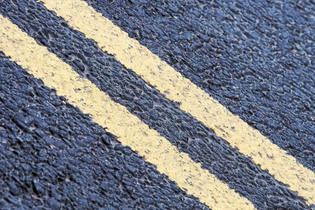 Double yellow lines on a road. Image by Andrew Martin from Pixabay