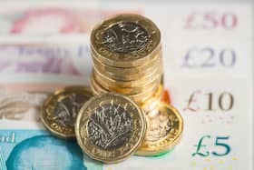 UK five pound, ten pound, twenty pound and fifty pound notes with one pound coins.