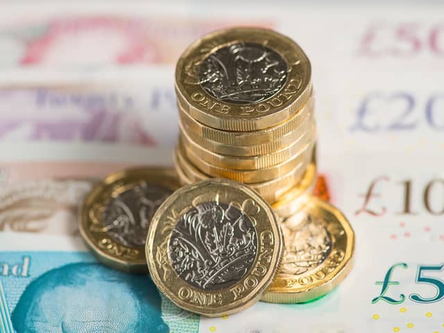 UK five pound, ten pound, twenty pound and fifty pound notes with one pound coins.